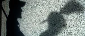 Der Schatten eines Malers ist auf einer Hauswand.