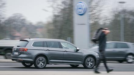 Volkswagen am Tor eines VW-Werksgeländes