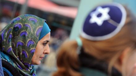 Eine Muslimin mit Kopftuch und eine junge Frau mit Kippa bei einer Protestaktion gegen Antisemitismus im Jahr 2012. 