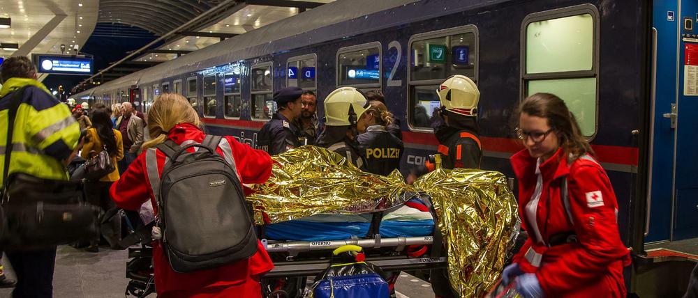 Einsatzkräfte versorgen verletzte Personen an einem Bahnsteig im Salzburger Hauptbahnhof.