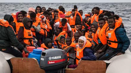 Flüchtlinge und Migranten warten auf einem überfüllten Schlauchboot darauf, gerettet zu werden (Symbolbild). 