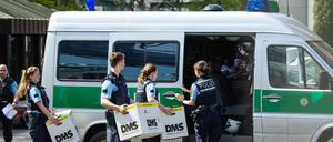Polizisten tragen bei der Razzia am Mittwoch Pappkartons zu einem Polizeiauto neben einem Porsche-Gebäude.