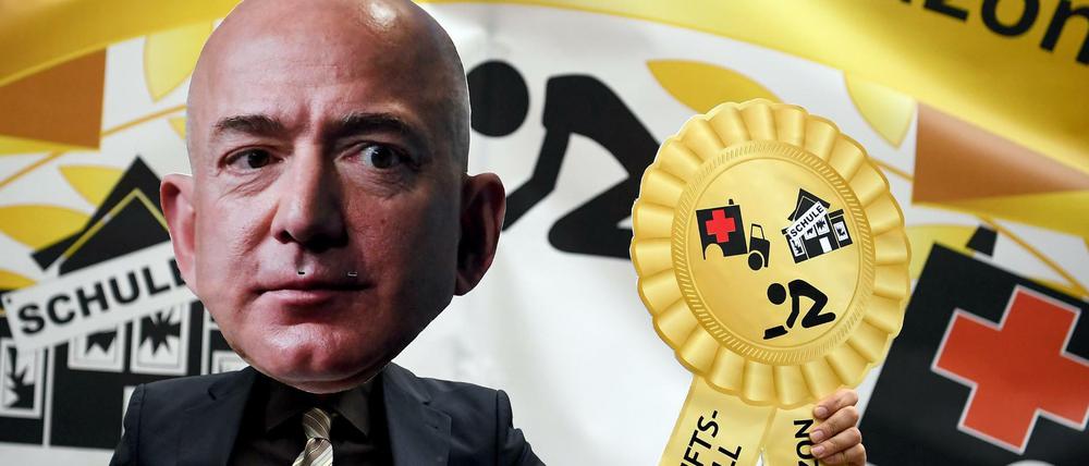 Ein Demonstrant trägt bei einer Protest-Demonstration die Maske des Amazon-Gründers Jeff Bezos.
