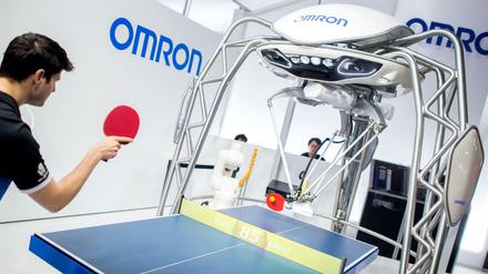 Tischtennisspieler Dimitrij Ovtcharov spielt bei der Hannover Messe am Stand von Omron gegen einen Roboter. 