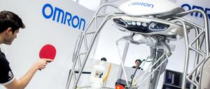 Tischtennisspieler Dimitrij Ovtcharov spielt bei der Hannover Messe am Stand von Omron gegen einen Roboter. 