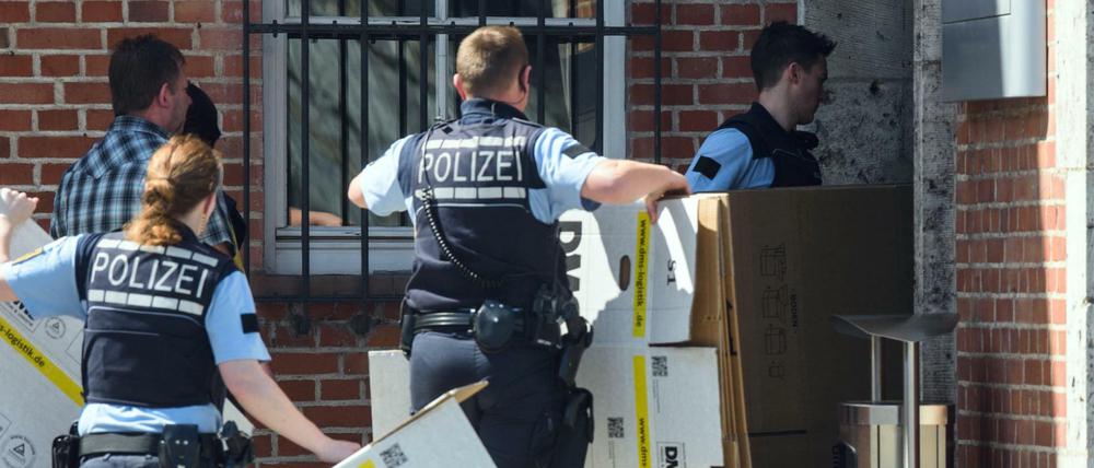 Polizisten mit Pappkartons vor dem Porsche-Gebäude.