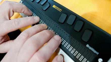 Eine Braillezeile zeigt den Bildschirminhalt am Computer in Punktschrift an. Das Bild zeigt, wie der Inhalt dann mit den Fingerkuppen ertastet wird.