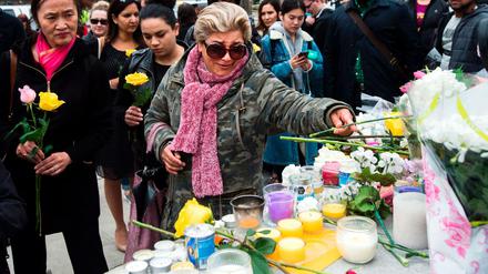 Menschen legen an einer provisorischen Gedenkstätte auf der Yonge Street Blumen nieder. 