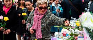 Menschen legen an einer provisorischen Gedenkstätte auf der Yonge Street Blumen nieder. 