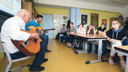 Gitarrenkünstler. Wilfried Ansin (links) und Janko Lauenberger von der Gruppe „Sinti Swing Berlin“ spielen vor Grundschülern in Hohenschönhausen. 