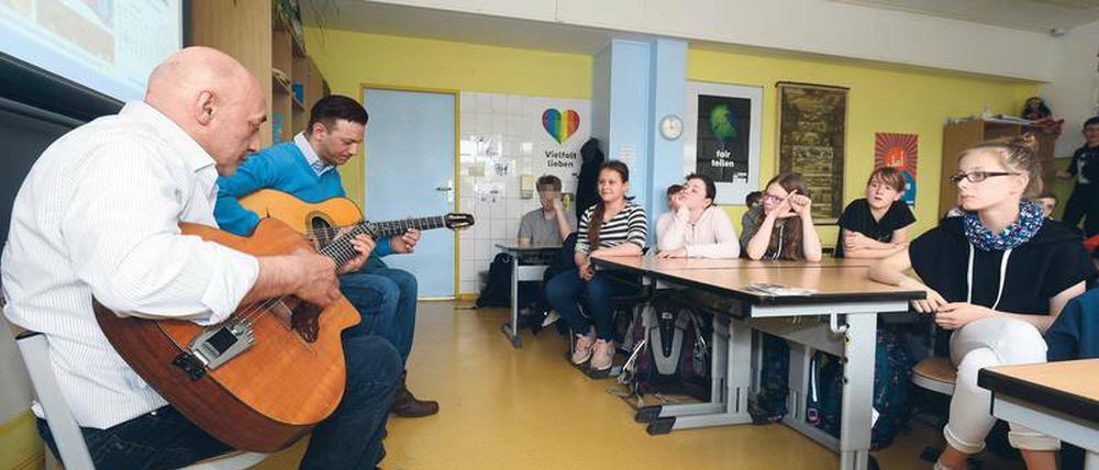 Gitarrenkünstler. Wilfried Ansin (links) und Janko Lauenberger von der Gruppe „Sinti Swing Berlin“ spielen vor Grundschülern in Hohenschönhausen. 