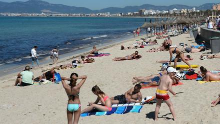 Touristen am Strand an der Playa de Palma in Arenal bei Palma de Mallorca.