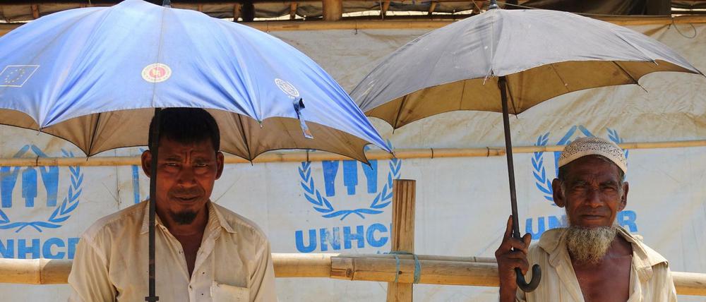 Diese Rohingya-Männer im Flüchtlingslager Kutupalong schützen sich Mitte April 2018 mit Schirmen vor der Sonne. 