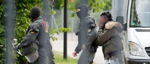 Ein Mann in Ellwangen wird von maskierten Polizisten eskortiert