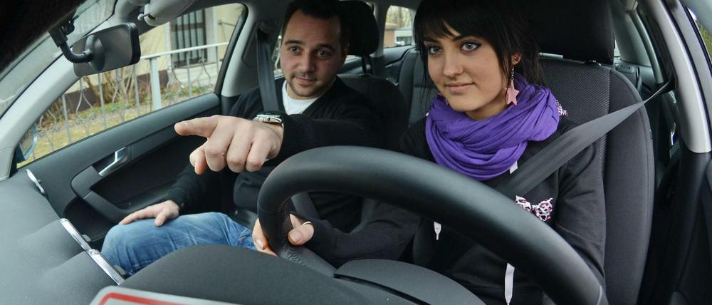 Fahrschülerin mit Fahrlehrer.