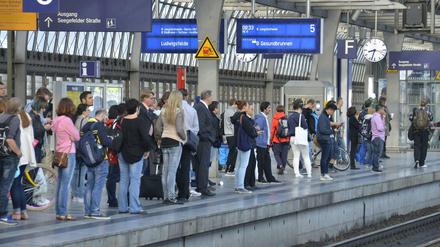 Reisende warten am Bahnhof Berlin-Spandau.