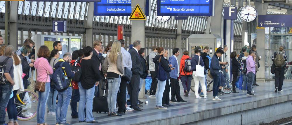 Reisende warten am Bahnhof Berlin-Spandau.