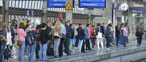 Reisende warten am Bahnhof Berlin-Spandau.