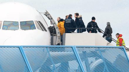 Abgelehnte Asylbewerber steigen in ein Flugzeug.