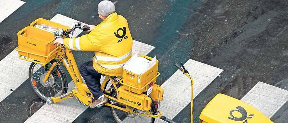 Bloß nicht krank werden - Ein Postbote versucht, sich mit wetterfester Kleidung zu schützen.