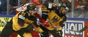 Enge Kiste. Dennis Seidenberg (rechts) und Frederik Tiffels (links) kämpfen mit Dänemarks Morten Madsen um den Puck.