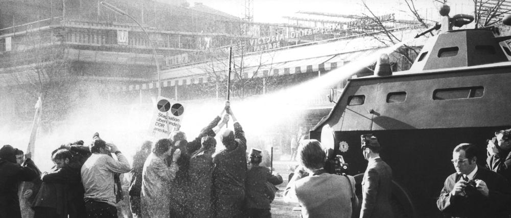 Demonstranten mit Kreuz stehen am Ostersonntag 1968 vor einem Wasserwerfer der Polizei auf dem Kurfürstendamm. Laut Polizeipräsident Moch gab es seit Juni 1967 vier ruhige Wochenende für die Polizisten.