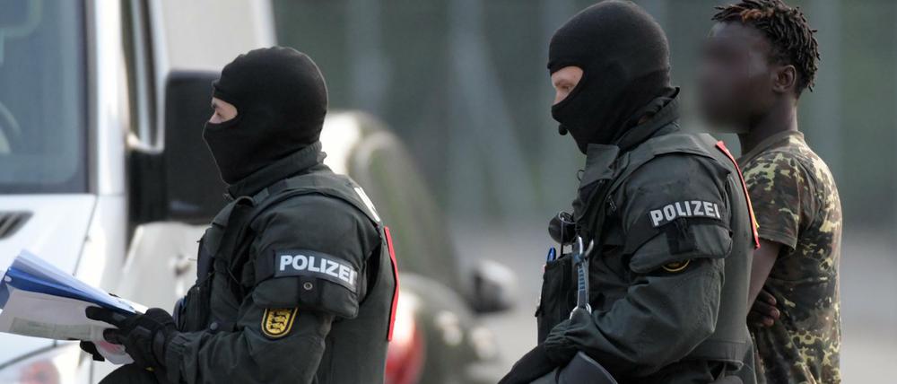 Das kann keine Lösung sein. Nach der Eskalation in Ellwangen eskortieren zwei Polizisten einen Asylbewerber. 