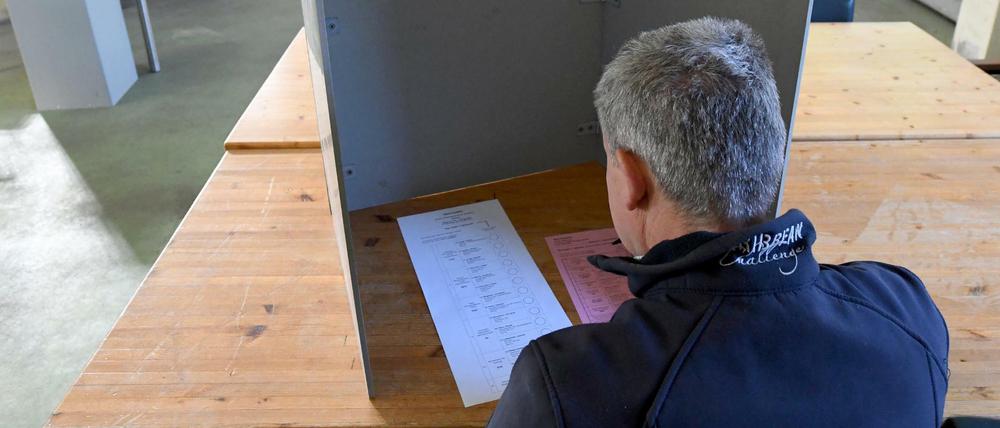 Ein Wähler sitzt bei der Stimmabgabe zur Kommunalwahl im Schleswig-Holstein im Gerätehaus der Freiwilligen Feuerwehr Homfeld.