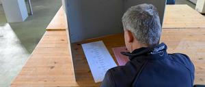 Ein Wähler sitzt bei der Stimmabgabe zur Kommunalwahl im Schleswig-Holstein im Gerätehaus der Freiwilligen Feuerwehr Homfeld.