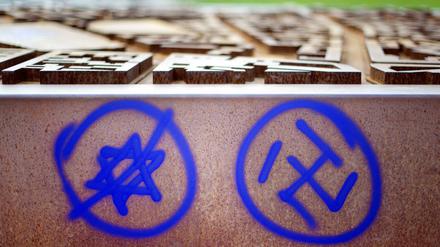 Ein Hakenkreuz und ein durchgestrichener Davidstern sind an einer Gedenkstätte in Berlin zu sehen. 