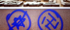 Ein Hakenkreuz und ein durchgestrichener Davidstern sind an einer Gedenkstätte in Berlin zu sehen.