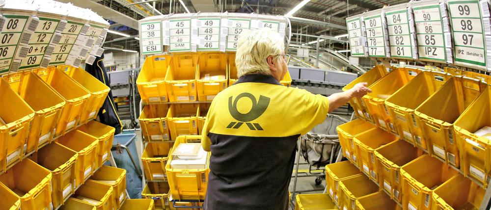 Eine Mitarbeiterin der Deutschen Post sortiert Großbriefe im Briefzentrum.