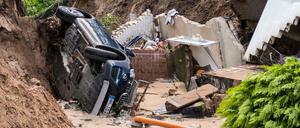 Ein Auto liegt in Hamburg-Lohbrügge in einer Senke die nach heftigem Regen entstanden ist.