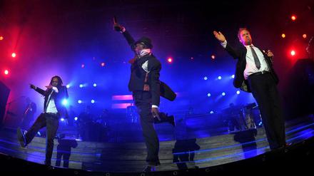Die Seeed-Sänger Peter Fox (r.), Eased (Frank A. Delle, l.) und Ear (Demba Nabe, M.) 2013 bei einem Konzert der Band in der Wuhlheide.