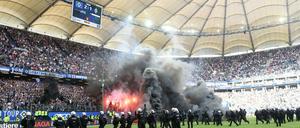 Randalierer zünden kurz vor dem Abpfiff in Hamburg Pyrotechnik, die Polizei sichert das Spielfeld. 