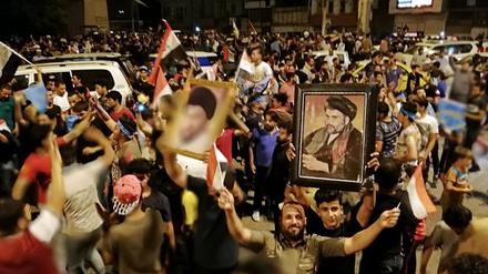 Anhänger des schiitischen Geistlichen al-Sadr jubeln in Bagdad nach ersten Hochrechnungen zur Parlamentswahl.