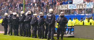 Policemen stand on the pitch after the German first division Bundesliga football match Hamburger SV vs Borussia Moenchengladbach, in Hamburg, nothern Germany, on May 12, 2018. / AFP PHOTO / Patrik STOLLARZ / RESTRICTIONS: DURING MATCH TIME: DFL RULES TO LIMIT THE ONLINE USAGE TO 15 PICTURES PER MATCH AND FORBID IMAGE SEQUENCES TO SIMULATE VIDEO. == RESTRICTED TO EDITORIAL USE == FOR FURTHER QUERIES PLEASE CONTACT DFL DIRECTLY AT + 49 69 650050