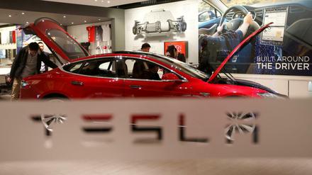 Ein Mann schaut in einem Showroom in Peking in einen Tesla Model S. 