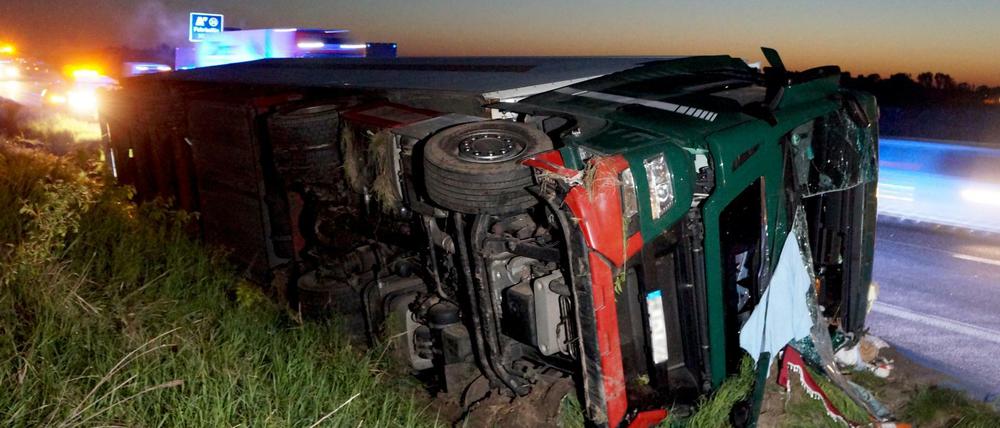Ein verunfallter Lkw liegt neben der Autobahn 24 in Fehrbellin (Brandenburg).