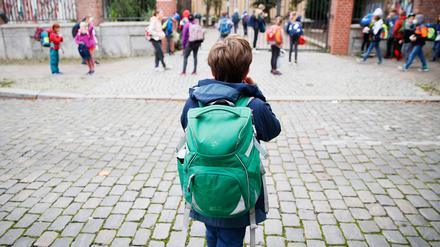 Schulkinder stehen vor einer Berliner Schule.