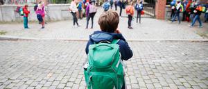 Schulkinder stehen vor einer Berliner Schule.
