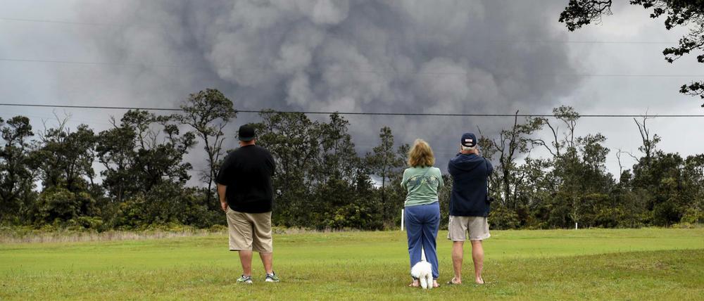 Menschen beobachten eine Asche-Wolke über dem Vulkan Kilauea.