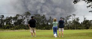 Menschen beobachten eine Asche-Wolke über dem Vulkan Kilauea.