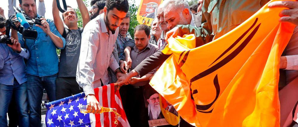 Aus Protest gegen die Kündigung des Atomabkommens verbrennen Demonstranten in Teheran eine US-Flagge.