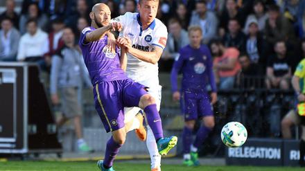 Der Karlsruher Marvin Pourie (r) und der Auer Philipp Riese kämpfen um den Ball. 