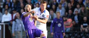 Der Karlsruher Marvin Pourie (r) und der Auer Philipp Riese kämpfen um den Ball. 