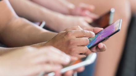 Menschen tippen auf ihre Smartphones (Symbolbild).