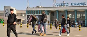 Ein Gruppe junger Männer verlässt im Februar 2017 in Begleitung eines Polizisten das Flughafengebäude in Kabul. 