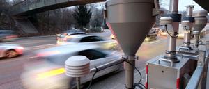 Autos fahren in Stuttgart an einer Feinstaub- und Luftmessstation vorbei.