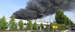 Großbrand im Europa-Park Rust. Flammen steigen über der Lagerhalle auf.
